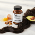 Hair+ suplemento capilar con ingredientes naturales sobre mármol